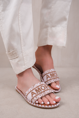 NOTE STRAP FLAT SANDALS WITH BEADED TEXT DETAIL IN WHITE FAUX LEATHER