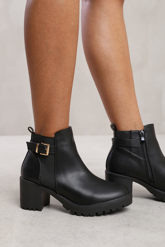 KALI MID BLOCK HEEL WITH BUCKLE DETAIL STRETCH ANKLE BOOTS IN BLACK FAUX LEATHER