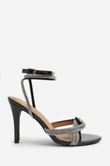 MADON WIDE FIT DIAMANTE KNOT DETAIL WITH CROSS OVER ANKLE STRAP HIGH HEELS IN BLACK PATENT