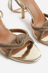 MADON WIDE FIT DIAMANTE KNOT DETAIL WITH CROSS OVER ANKLE STRAP HIGH HEELS IN GOLD CHROME